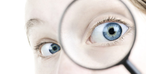 Eye looking thorough magnifying glass