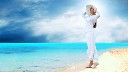 Fototapeta na wymiar Young beautiful women in the white on the sunny tropical beach