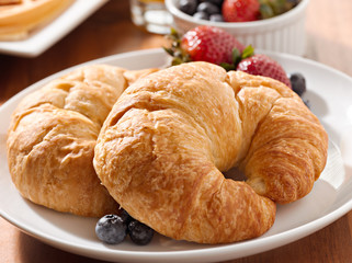 breakfast with two croissants and berries.