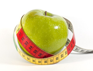 Green apple with measuring tape on white background
