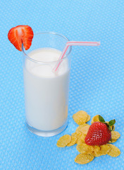 Glass of milk and cornflakes on a blue background