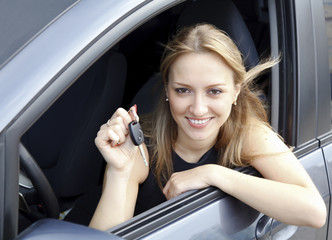 Fototapeta na wymiar Szczęśliwa kobieta wykazujące klucz jej nowy samochód.