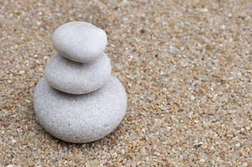Fototapeta na wymiar several zen stones on the sand background