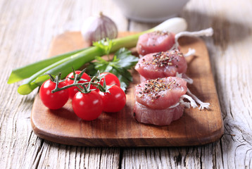 Raw pork tenderloin and vegetables