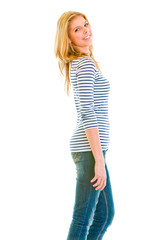 Portrait of smiling teengirl standing profile isolated on white.