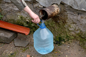 The female hand holds plastic bottle with water