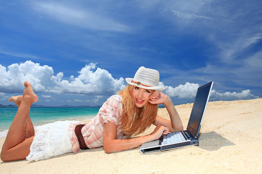 ビーチでインターネットを楽しむ笑顔の女性