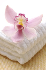 Spa towels with pink orchid on mat