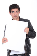 Young man in a leather jacket holding a board