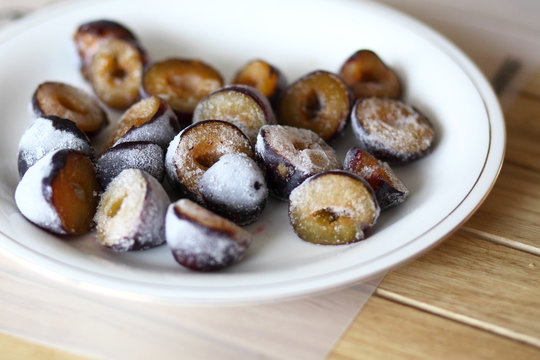 Frozen, defrosting plums on a plate