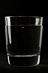 Glass of water on black background