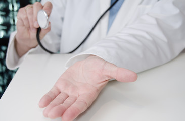 Arzt mit einem Stethoskop hält die Hand auf
