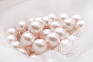 Fototapeta na wymiar pink pearls on the tulle
