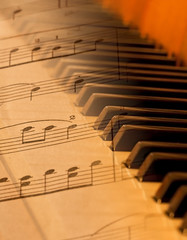 Sheet music blended over piano in soft light blurred