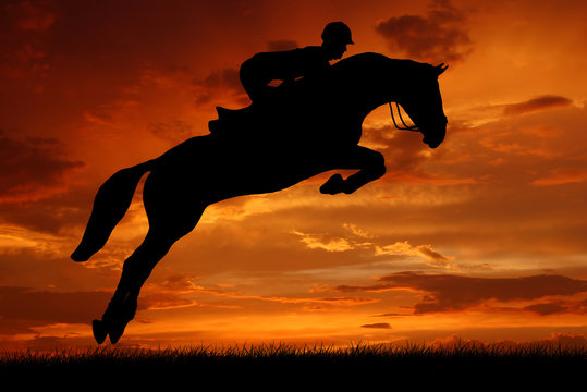 silhouette of a rider on a jumping horse
