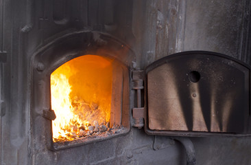 Open iron stove in boiler room