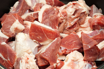 Closeup of raw meat in a pot, ready for cooking.
