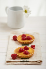 raspberry tart on a napkin, in background white flower