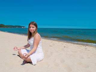 Fototapeta na wymiar woman practicing yoga on sea beach