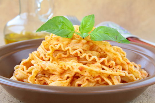 Italian pasta tripoline with tomato sauce and basil