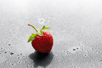 red strawberry with water drops over black