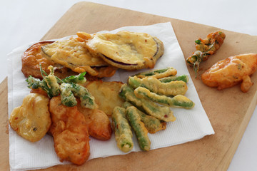Fried vegetables in batter on a chopping board