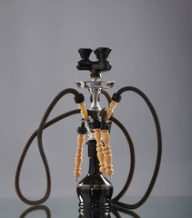 An old brown Arabic hookah on a grey background