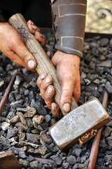 Detail of dirty hands holding hammer - blacksmith