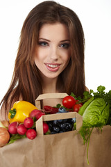 Portrait of happy woman holding a shopping bag full of groceries