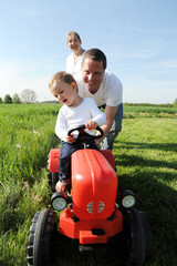 Eltern und Kleinkind mir rotem Traktor © AndiPu