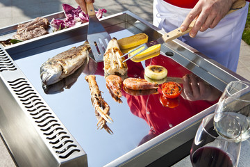 professional chef cooking fish on a barbeque