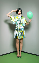 Fashion shoot of a woman in a dress and holding a balloon