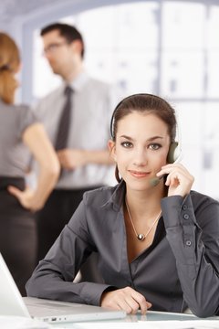Young customer servicer using headphones in office