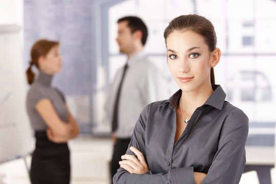 Young office worker standing arms crossed