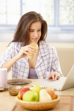 Woman using laptop at breakfast