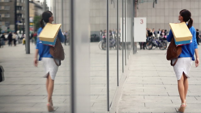 Attractive woman with shopping bags looking at shop window