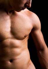 Young man with naked torso on black background
