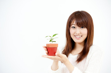 a portrait of beautiful asian woman with small plant