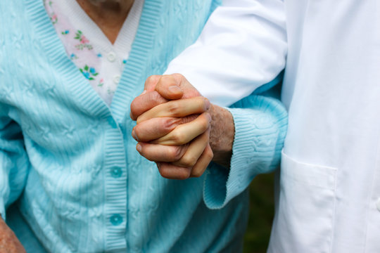 Senior lady with doctor, holding hands
