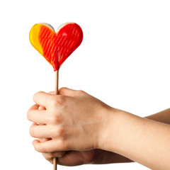 hand holding lollipop heart isolated on white