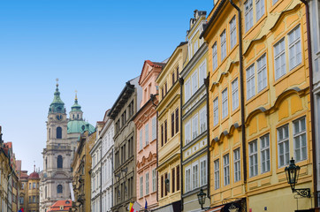 Fototapeta na wymiar Praga ulicy z kolorowych domów i kościół z wieżą zegarową
