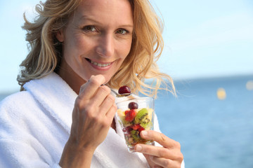 portrait of a woman eating fruit salad