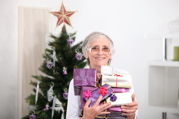 Obraz na płótnie Canvas Old woman holding Christmas presents