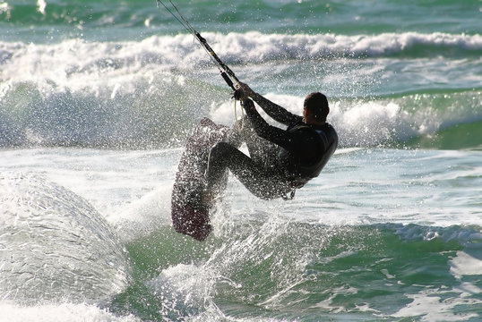 Kitesurfer jumps over the water on Mediterranean Sea.