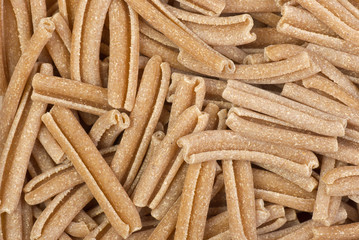 Food background: uncooked bran pasta