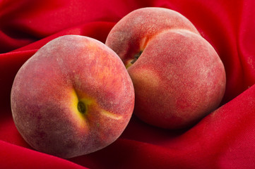 fresh peach fruits on red velvet