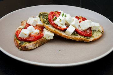 Bruschetta with dry tomatos, feta cheese and basil
