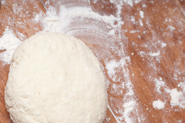 hands in flour closeup kneading dough on table
