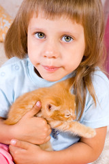 Girl hugs ginger kitten