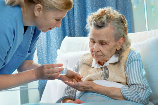 Nurse gives a senior patient the midicine